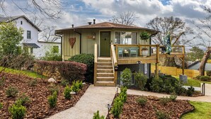 A two-story house with a front porch, a staircase, and a small deck. - The Hobbit House - City Views/Deck & Patio/Firepit (birmingham)