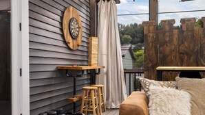 A deck with a dartboard, stools, and a table. - Warren Home: A Glimpse into BHAM's Rich Past (birmingham)