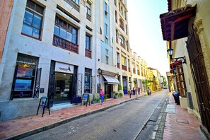 A street with buildings, a sidewalk, and a few pedestrians. - Loft overlooking the historic center of cartagena (Cartagena de Indias)