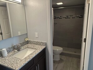 Suite estudio Deluxe, 2 camas de matrimonio | Baño | Ducha, secador de pelo, toallas y jabón
