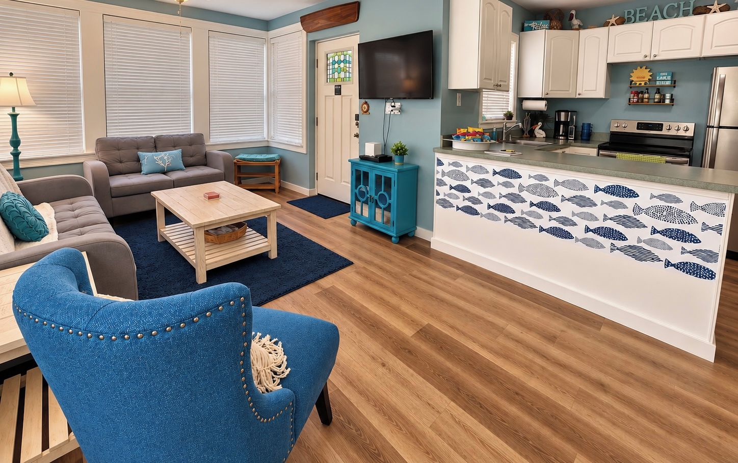 A living room with a sofa, coffee table, and a blue armchair.