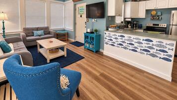 A living room with a sofa, coffee table, and a blue armchair.