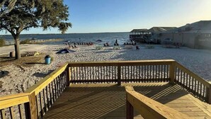 A wooden deck overlooking a beach with a pier in the background. - Cozy Cottage At Lake Weir (Ocklawaha)