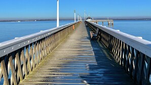 A pier extending into calm waters with a clear sky. - Charming 2-bed Family Cottage Your West Bay Retreat (Yarmouth)