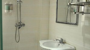 A bathroom with a shower, a sink, and a mirror. - Haojia Community Hotel (Zhengzhou Zhengdong New Area Branch) (Zhengzhou)