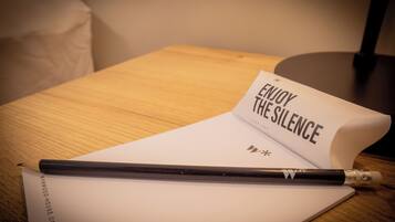 A notebook with a pencil on a wooden table.