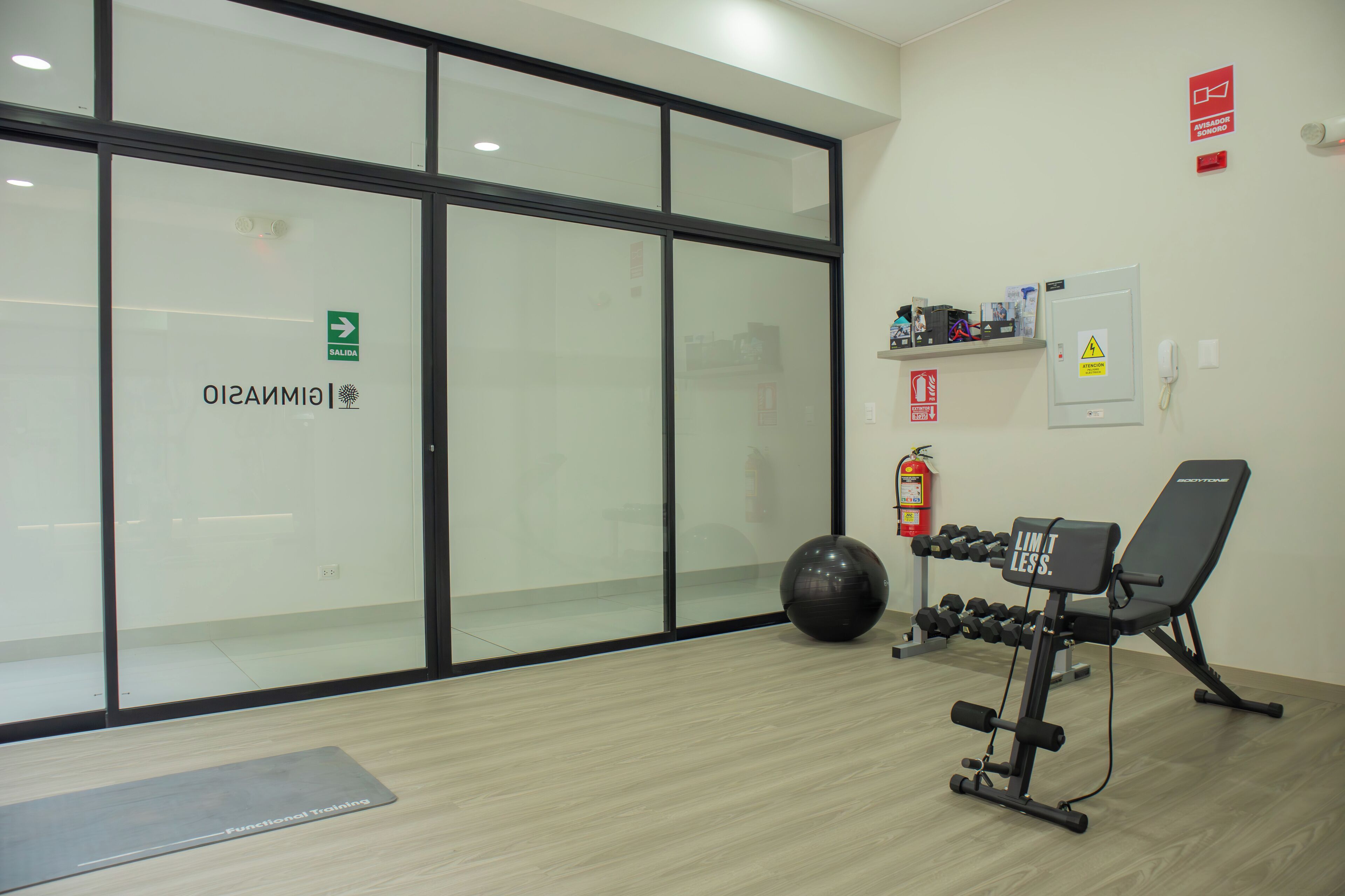 A fitness center with exercise equipment, a dumbbell rack, and a ball.