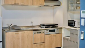 Une cuisine moderne avec des meubles en bois, des appareils électroménagers en acier inoxydable et un four à micro-ondes.