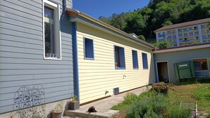 Una casa de dos pisos con fachada azul y detalles amarillos.