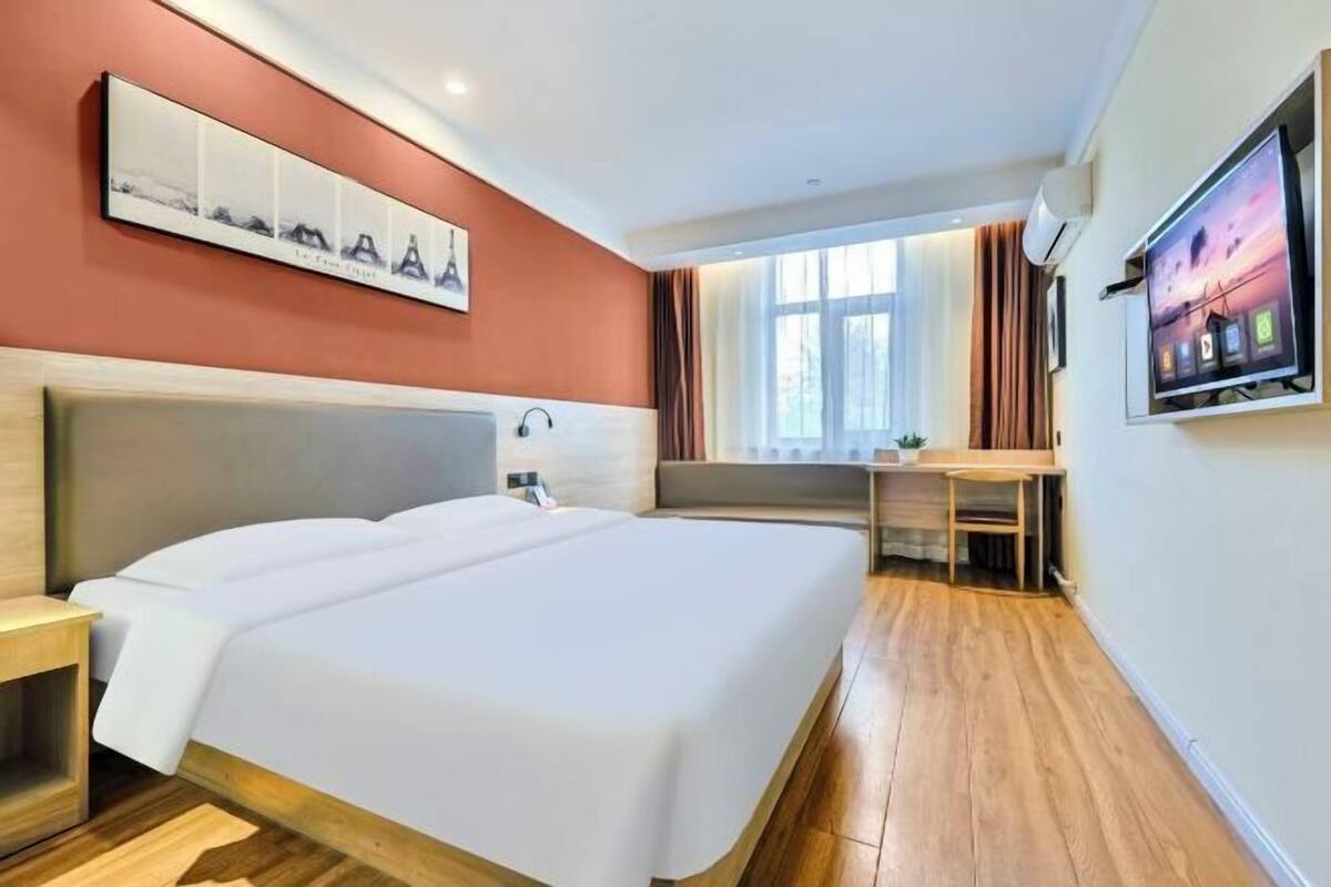 Ein Hotelzimmer mit einem großen Bett, einem Schreibtisch und einem Fernseher.