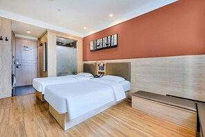 A hotel room with two beds, a wooden floor, a red accent wall, and a painting. - Meiyang Boutique Hotel (Shijiazhuang Xinhua Road 54 Office) (Shijiazhuang)