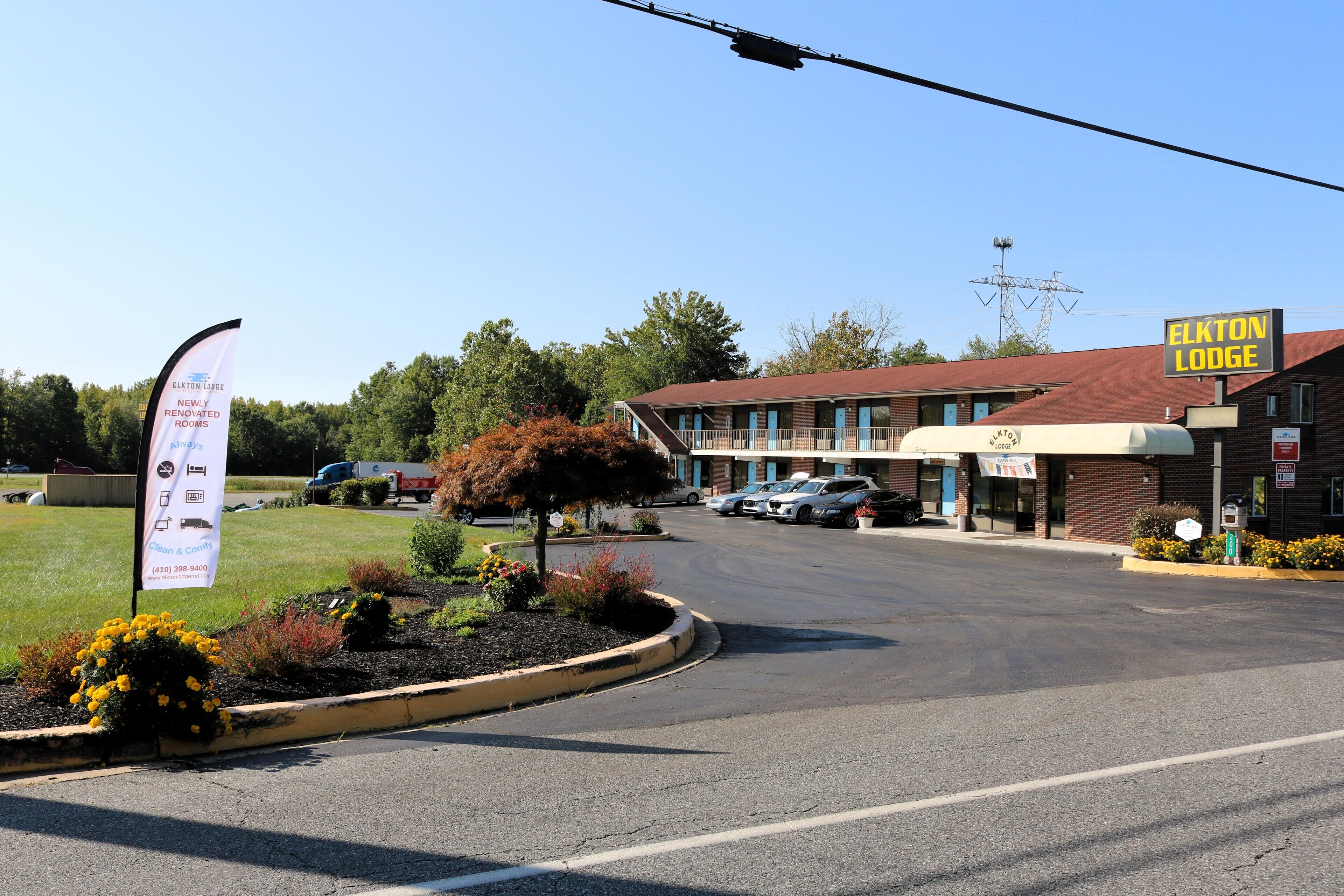 A motel with a red roof, a parking lot, and a sign for Elkton Lodge.