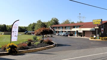 A motel with a red roof, a parking lot, and a sign for Elkton Lodge.