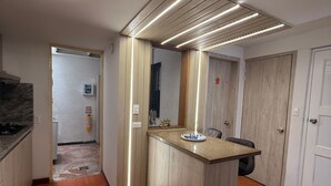 A modern kitchen with a wooden island, a built-in oven, and a tiled floor.