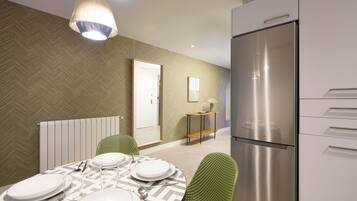 Una cocina moderna con un refrigerador de acero inoxidable, una mesa de comedor para cuatro personas y sillas verdes.