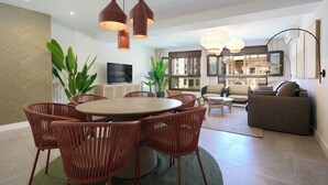 Un salon moderne avec une table de salle à manger ronde, des chaises en osier rouges et un canapé.