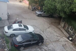 A parking area with two cars and a motorcycle. - Tongling Xingshang Express Hotel (Tongling)