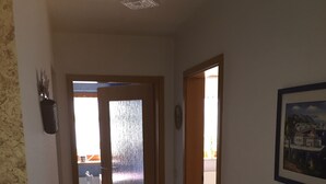 A hallway with wooden flooring, a glass door leading to a room, and a framed picture on the wall. - Vacation apartment Philipp (Emmingen-Liptingen)