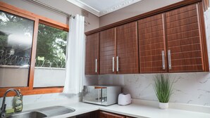 Una cocina con armarios de madera, microondas, tostadora y lavabo.