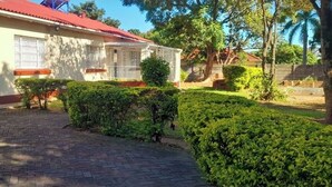 A building with a red roof, a paved entrance, and well-maintained hedges. - Marcifen (Harare)