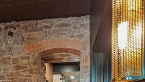 A hallway with stone walls, a wooden floor, and a number sign '103'. - EXPLORE Marquette Historic District (Marquette)