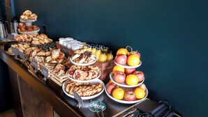 A buffet with various pastries, fruits, and beverages. - EXPLORE Marquette Historic District (Marquette)