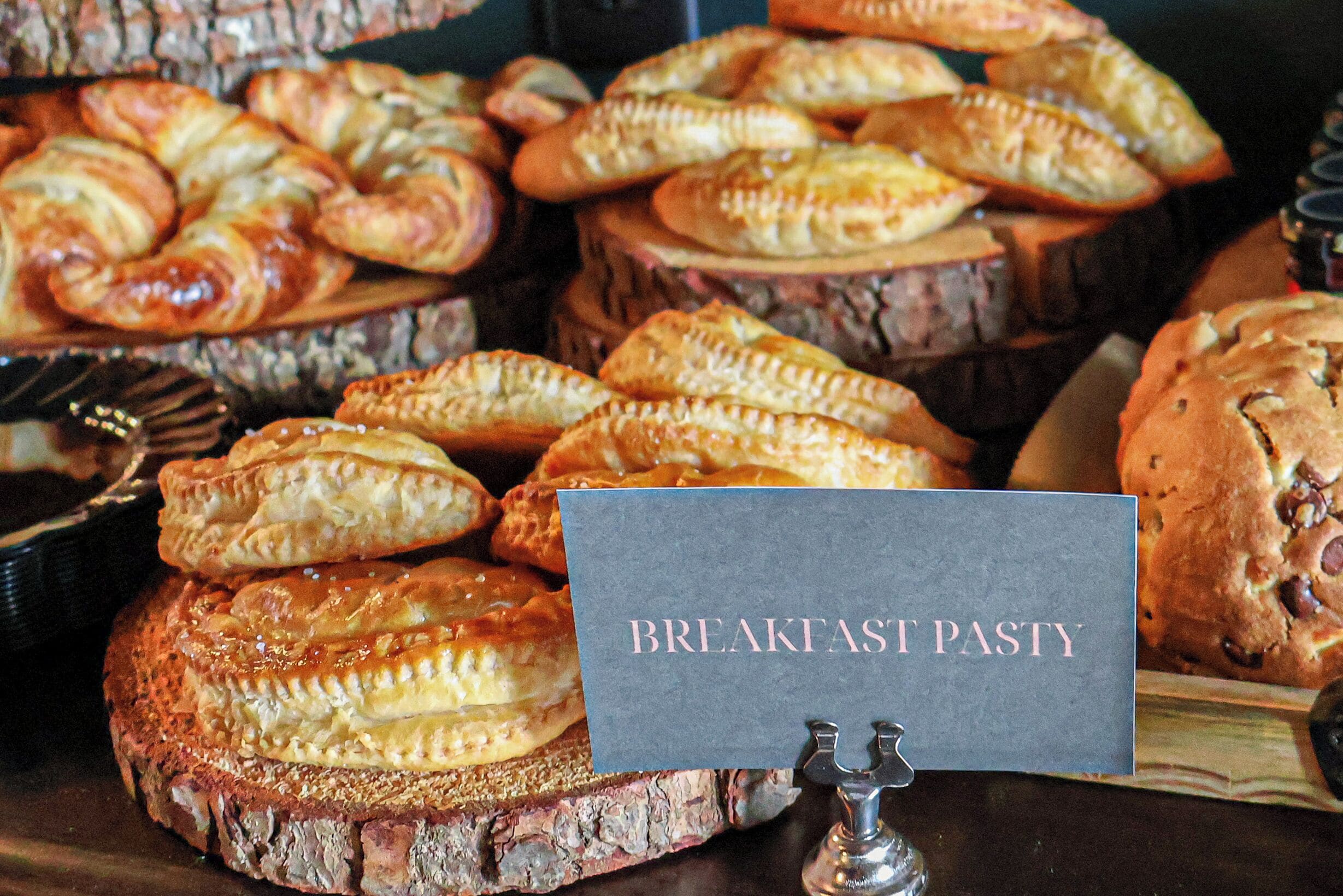 A display of breakfast pastries with a sign labeled "BREAKFAST PASTY".