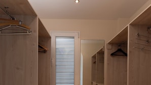 A walk-in closet with wooden shelving and drawers, a window with blinds, and a wooden floor. - Villa Paraíso in Mojácar with pool for 14 guests – 7 bedrooms – 3.5 bathrooms (Mojácar)