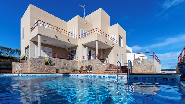 A modern hotel with a pool, stone facade, and multiple balconies. - Villa Paraíso in Mojácar with pool for 14 guests – 7 bedrooms – 3.5 bathrooms (Mojácar)
