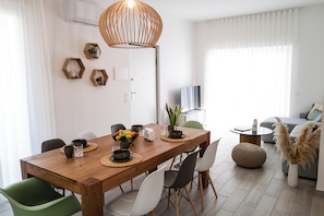 Un comedor moderno con una mesa de madera, repisas hexagonales y un lámpara colgante.