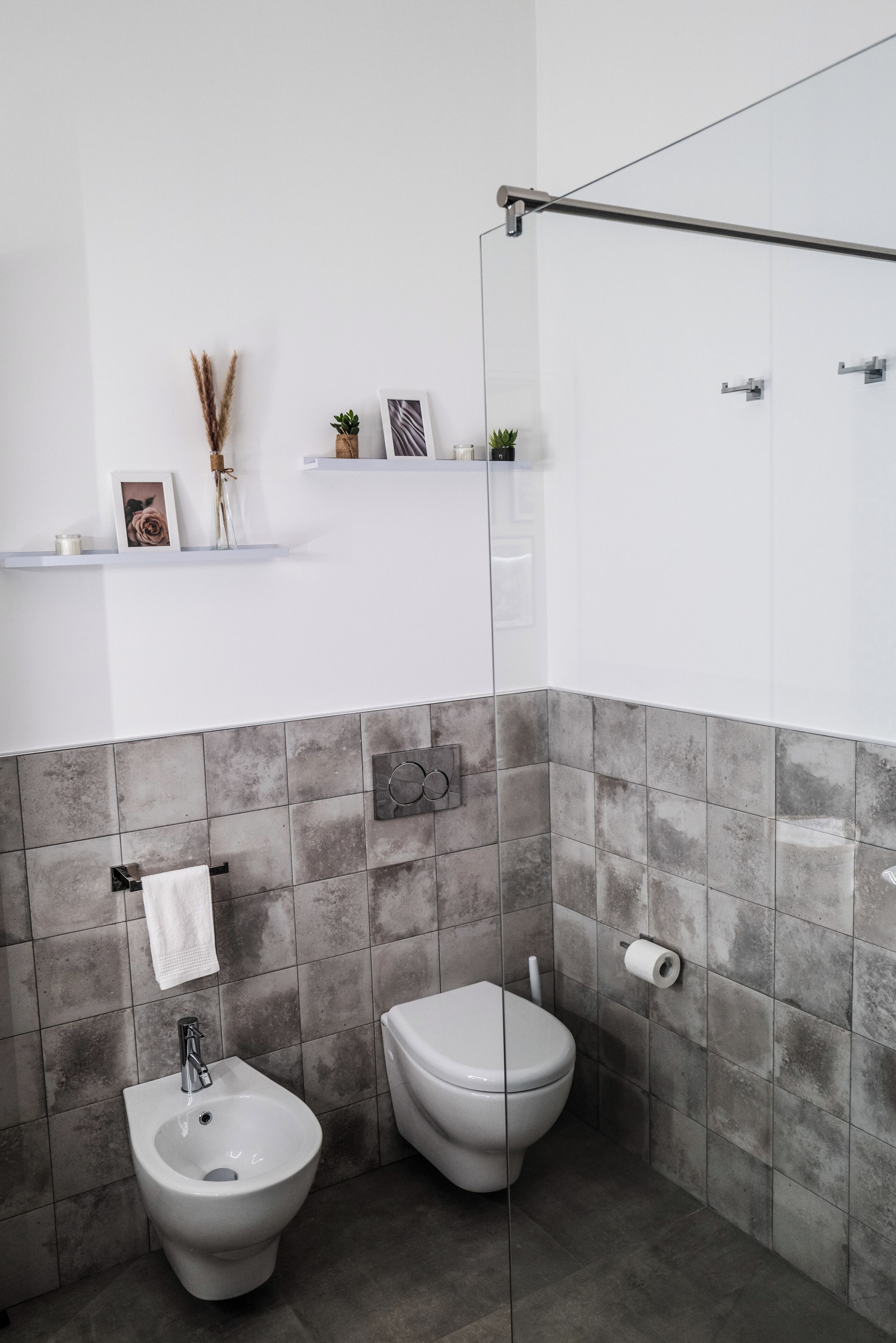 Un bagno moderno con bidet, toilette e cabina doccia in vetro.