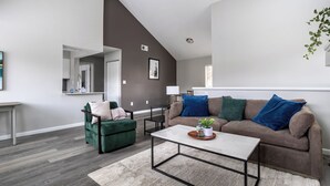 Ein modernes Wohnzimmer mit einem braunen Sofa, einem grünen Sessel und einem weißen Couchtisch.