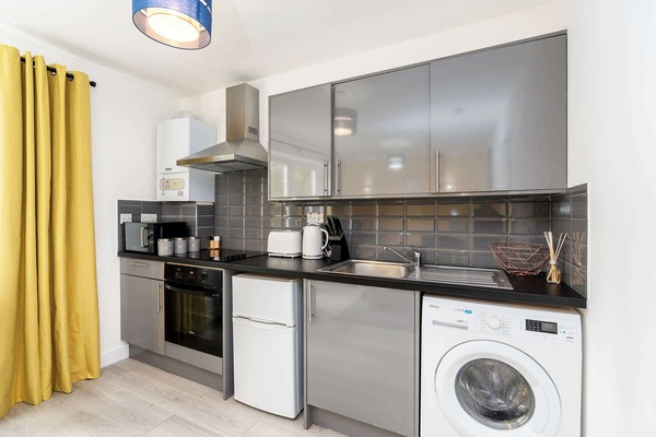The kitchen is fully equipped with all the appliances you might need, including a fridge with a small freezer, microwave, kettle, toaster, oven with hob, and for your laundry needs, a washer/dryer
