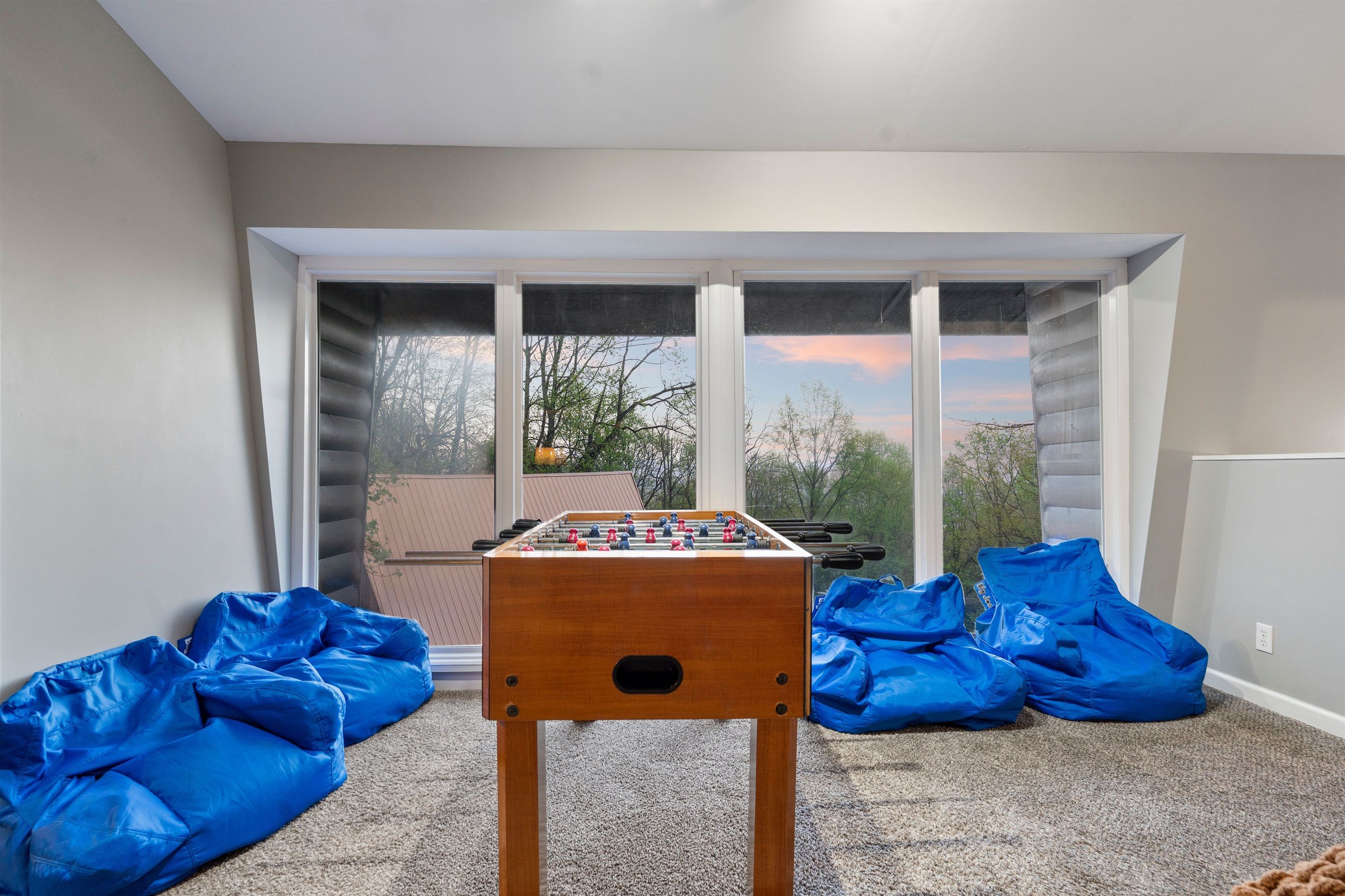 Foosball, floor-to-ceiling views, and bean bag lounging—this upstairs space is made for fun and unwinding