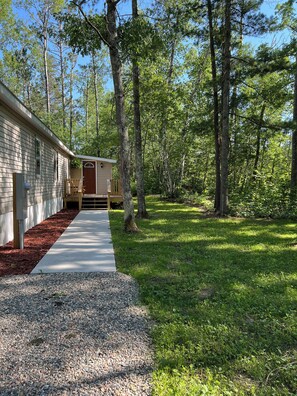Un sendero que lleva a una pequeña cabaña en un área boscosa.