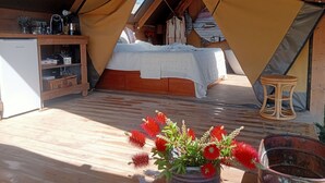 A cozy attic bedroom with a bed, a small table, and a potted plant. - Boutique eco Agriturismo nestled among ancient olive trees and stunning Tuscan hills (Santa Luce)