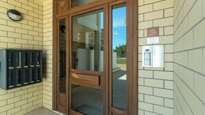 A hotel entrance with a wooden door, a mailbox, and a wall-mounted sign indicating room number 15. - Appartamento Orione (Lecce)