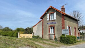 A two-story building with a red-tiled roof and a sign reading "St Georges de la Rivière". - A unique stay in an old railway station, in the heart of the Cotentin sea & countryside. (Saint-Georges-de-la-Rivière)