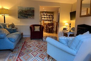 TV connectée, cheminée, livres, chaîne hi-fi