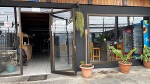 A modern building with a wooden facade, glass entrance, and potted plants outside. - La casona rio 2  (Río Segundo)