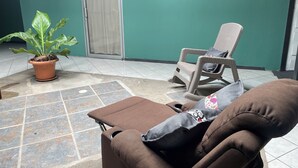 A lounge area with a brown sofa, a wicker chair, and a potted plant. - La casona rio 2  (Río Segundo)