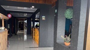 A corridor with wooden beams, a reception desk, and a potted plant. - La casona rio 2  (Río Segundo)