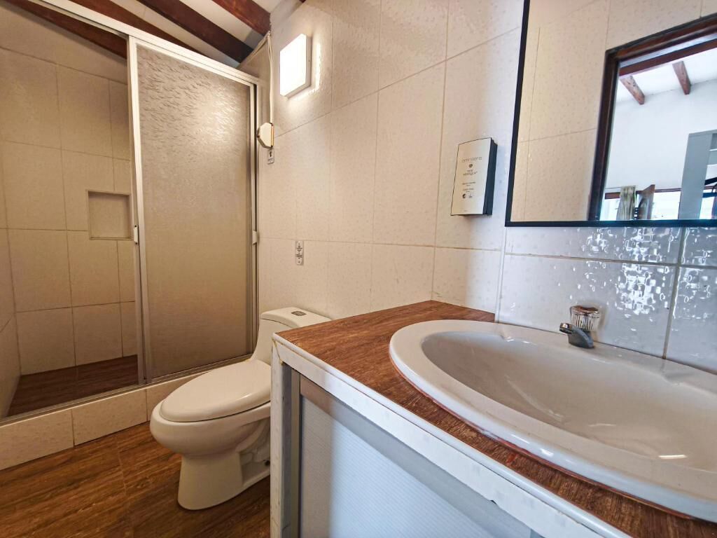 Un baño con ducha, inodoro y lavabo.