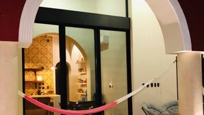 A room with two lounge chairs, a glass door leading to a dining area, and a ceiling fan. - Luxury Home & Pool, 5 Min from Downtown (Merida)