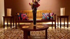 A dining area with a round table, two chairs, a bench with colorful cushions, and a vase with flowers. - Luxury Home & Pool, 5 Min from Downtown (Merida)