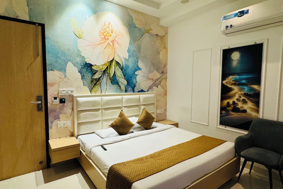 Een slaapkamer met een groot bed, een muurschildering van een nachthemel en een houten deur.
