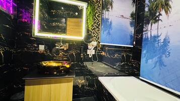 A modern bathroom with a black and gold marble design, a large mirror, a bathtub, and a wall-mounted sink.