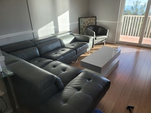 A living room with a sectional sofa, a coffee table, and a chair. - WATERFRONT PENTHOUSE 1BD/1BA Sunset Suite 5 MIN to DOWNTOWN LIVE MUSIC & BEACHES (St. Petersburg)
