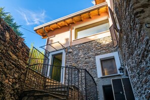 A stone building with a wooden staircase leading to a second-floor entrance.