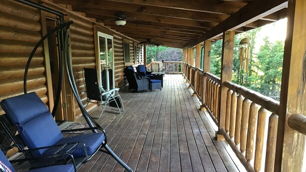 A wooden deck with lounge chairs and a table, overlooking a forested area. - Spacious 5 bedrooms, three stories log cabin with WiFi, AC in charming Bronston (Bronston)